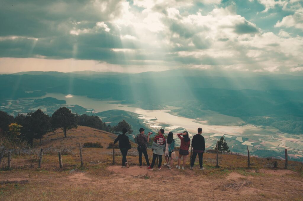 A group of people admire the beautiful valley and dramatic sky, perfect for travel and nature concepts.